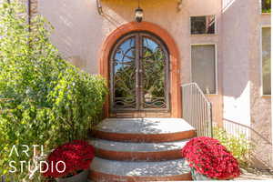 Arched entryway featuring ornate double doors with decorative copper