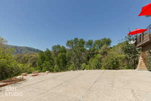 Expansive outdoor patio area featuring a concrete surface and natural stone edging