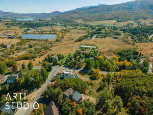 Expansive aerial landscape featuring a lake, surrounding natural terrain, and distant mountains