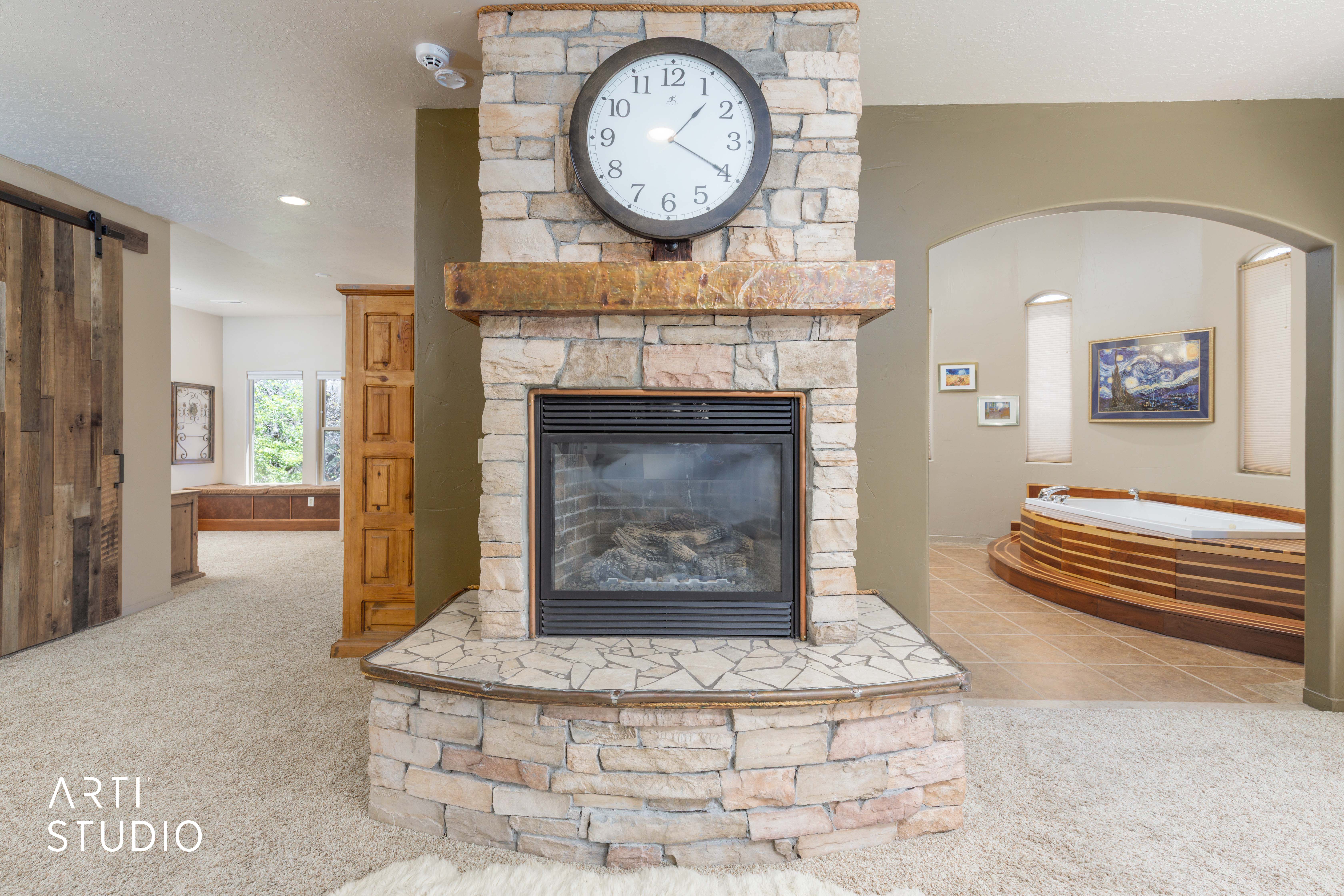 Stone-clad fireplace with a wood mantle and gas insert