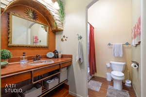 Bathroom featuring a vanity with a wood-finish countertop, an inset basin sink, and an ornate framed mirror