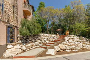 Terraced landscaping featuring natural stone retaining walls and mature trees