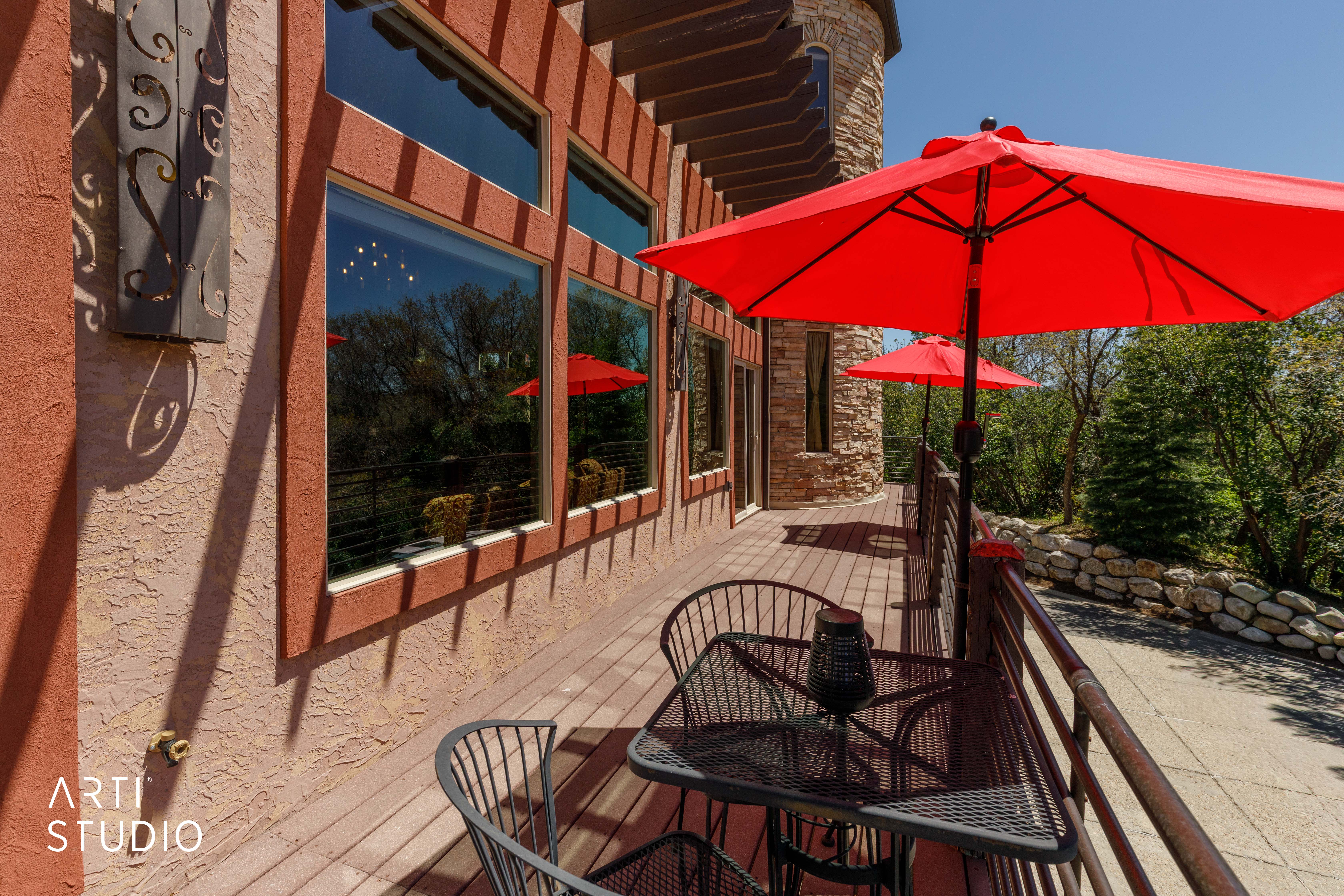 Expansive outdoor deck featuring wood-finish flooring and a decorative metal railing