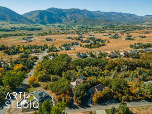 Expansive mountainous landscape featuring a residential area with mature trees and paved roads