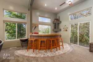 Built-in bar with stone countertop and mosaic tile flooring
