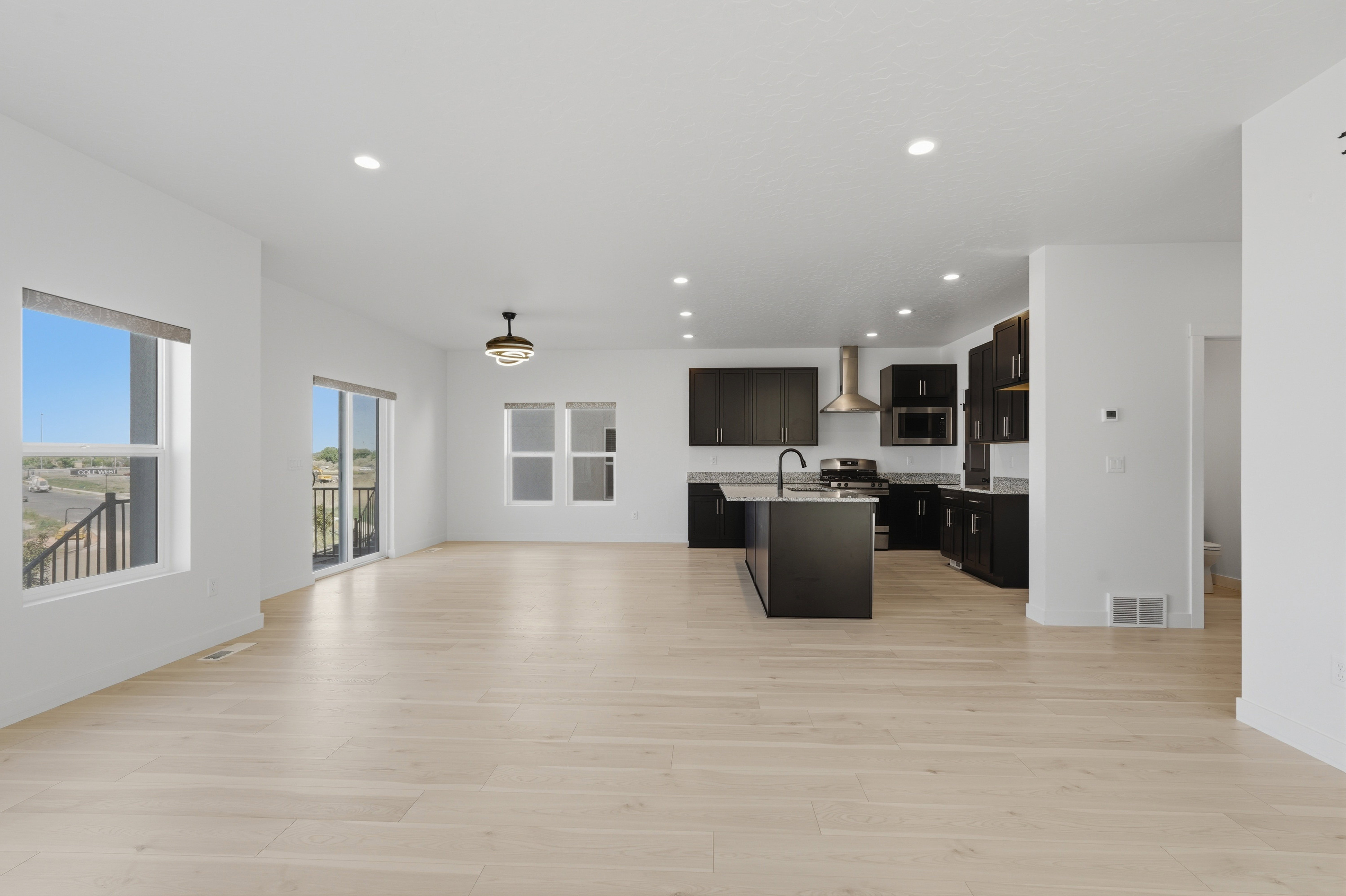 Expansive open-concept living area featuring light wood-finish flooring