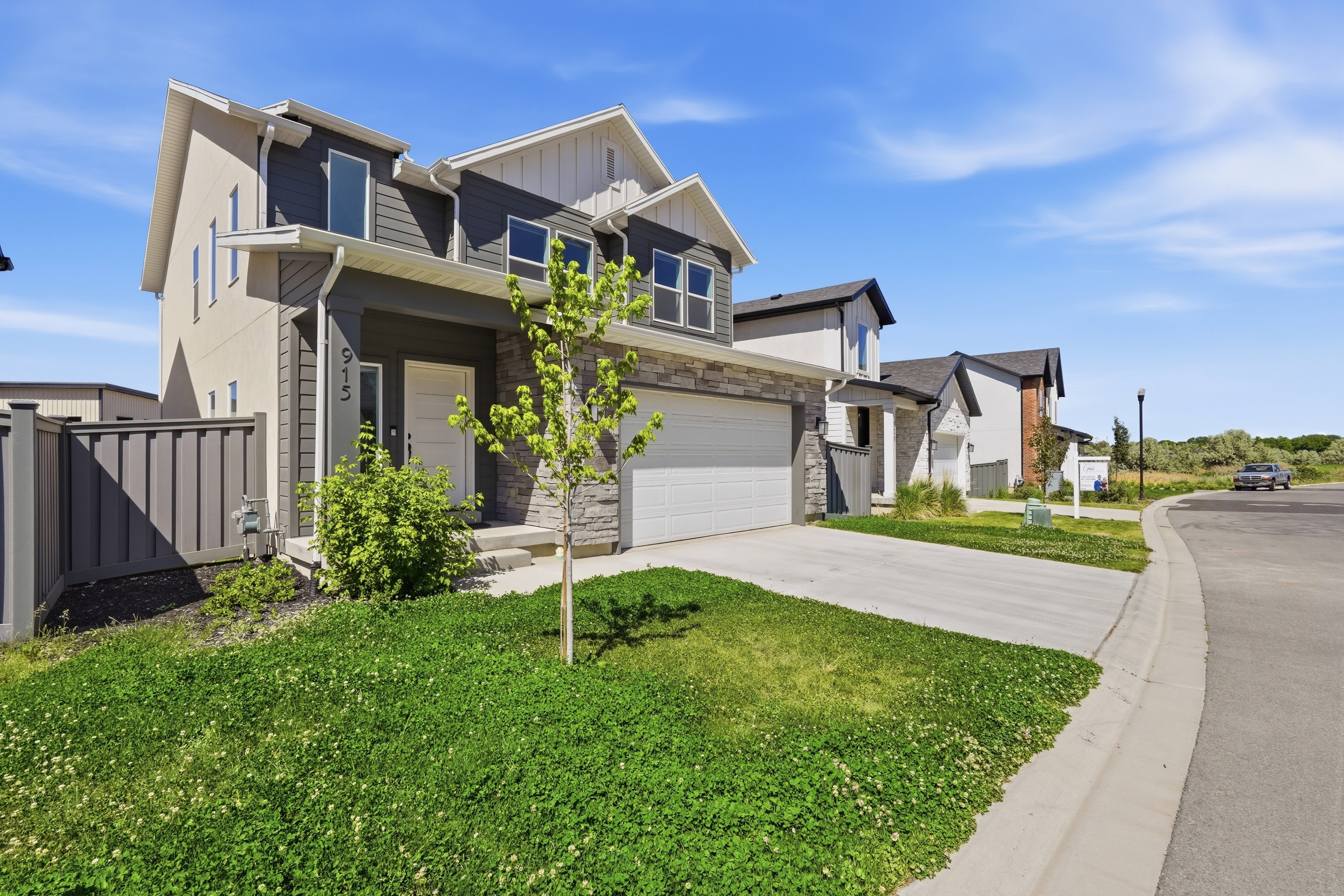 Contemporary two-story exterior with a two-car garage, stone and siding accents, and a concrete driveway