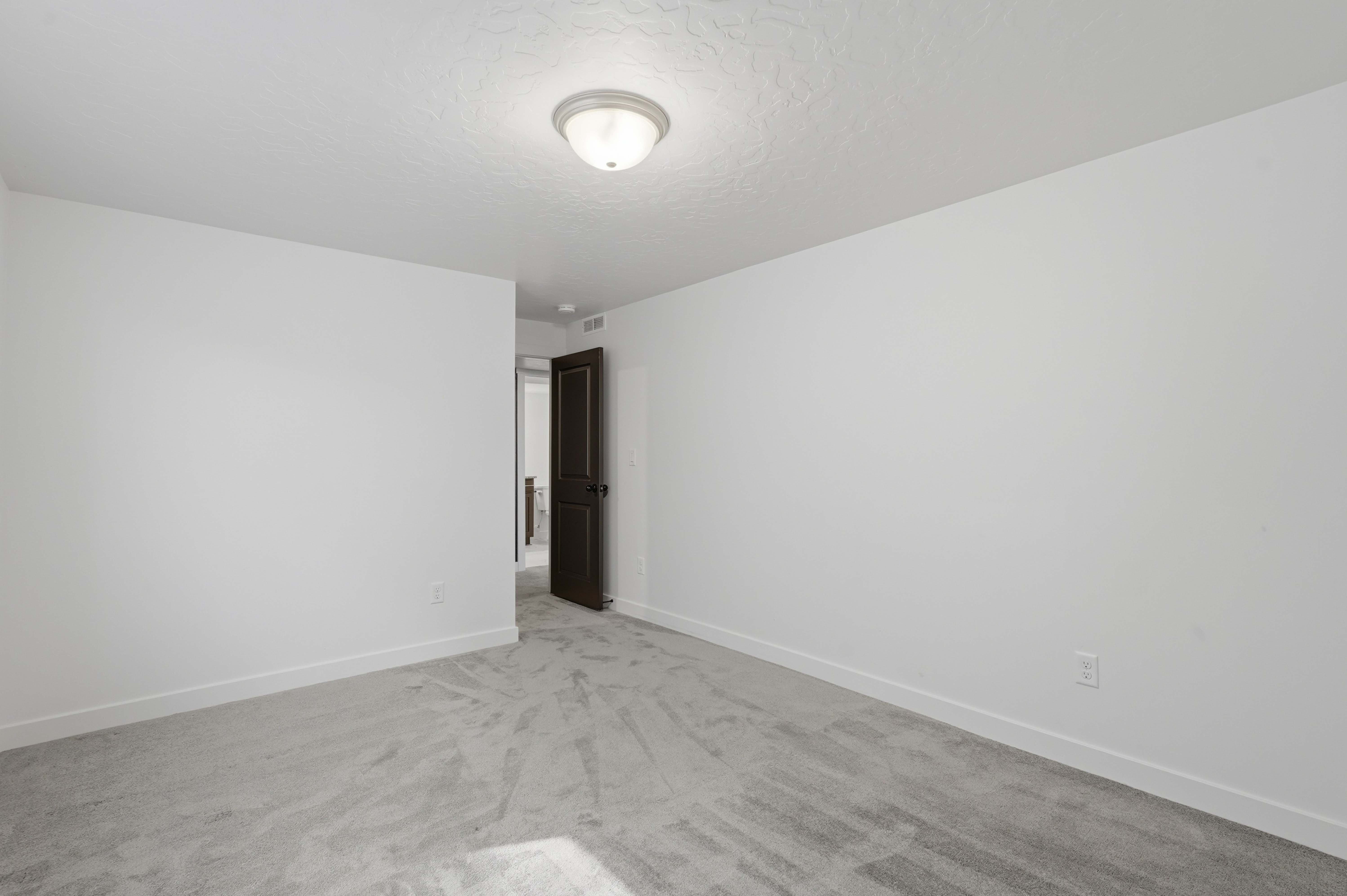 Neutral white walls with matching baseboards, textured ceiling, and a flush mount ceiling light