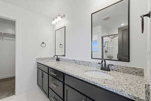 Dual vanity with granite-style countertop, undermount sinks, and dark cabinetry