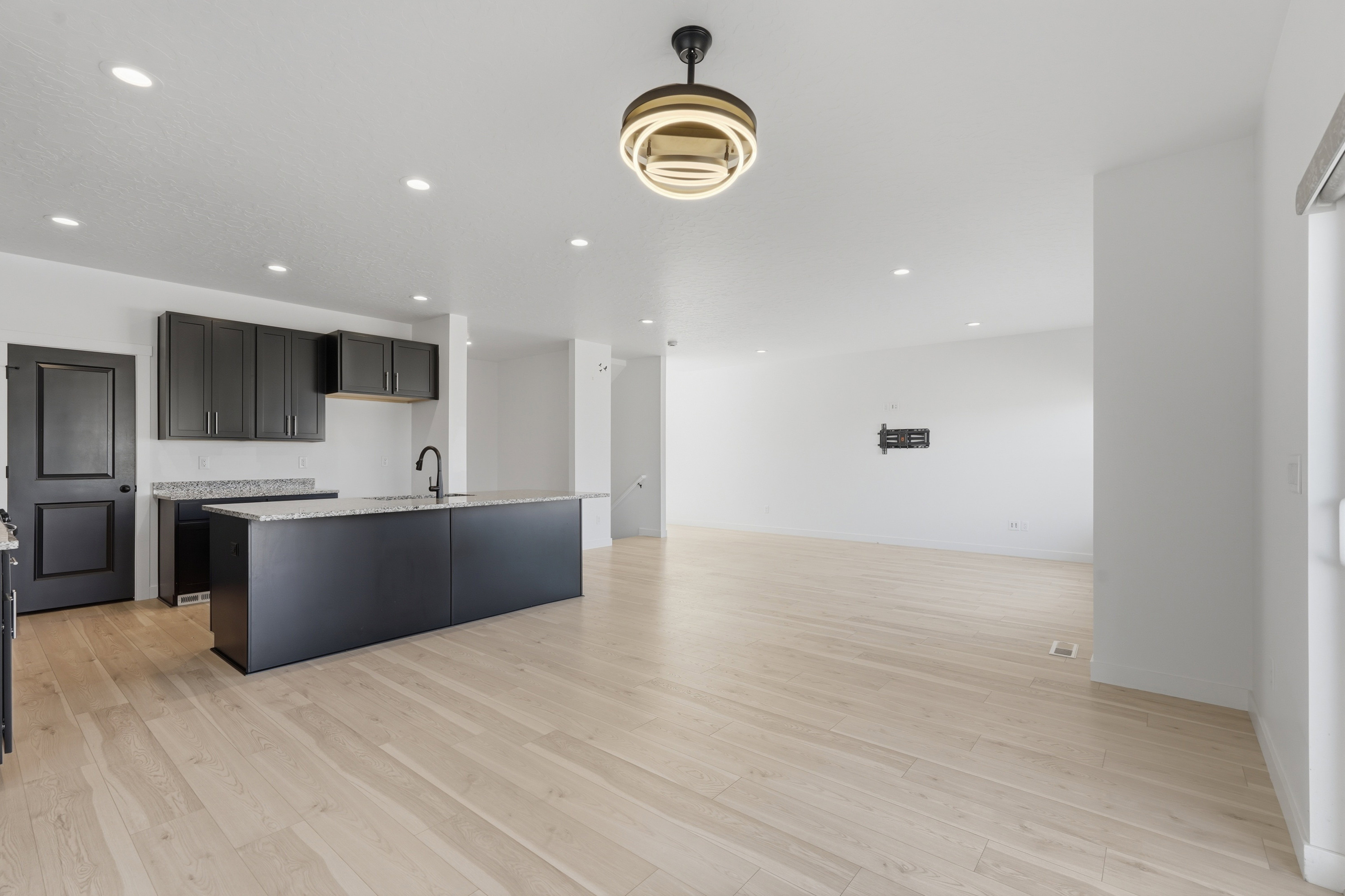 Open concept living space featuring light wood-finish flooring, recessed lighting, and a modern ceiling fixture