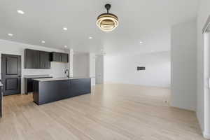Open concept living space featuring light wood-finish flooring, recessed lighting, and a modern ceiling fixture