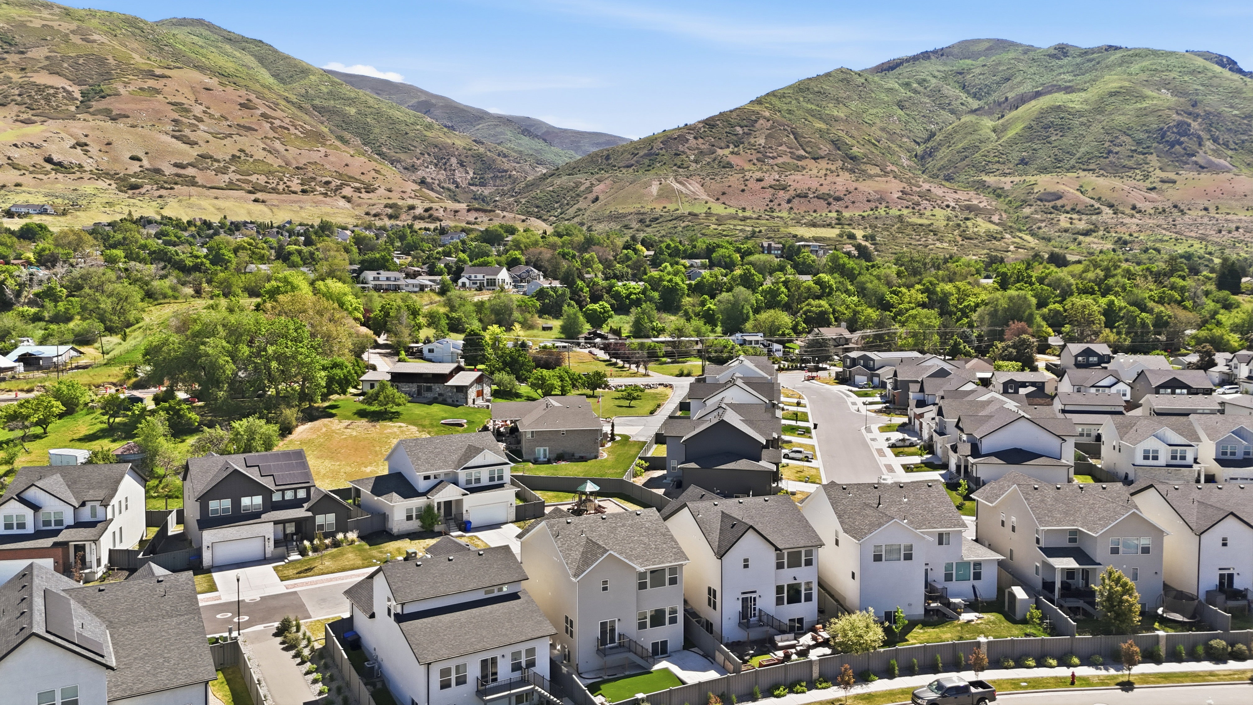 New construction properties nestled within a residential community, featuring consistent architectural styles and mountain scenery