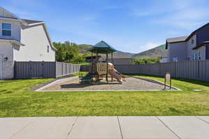 Community playground featuring a multi-level play structure with slides and climbing elements, set on a gravel base