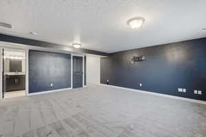 Spacious room featuring patterned carpeting, recessed lighting, and a dark accent wall