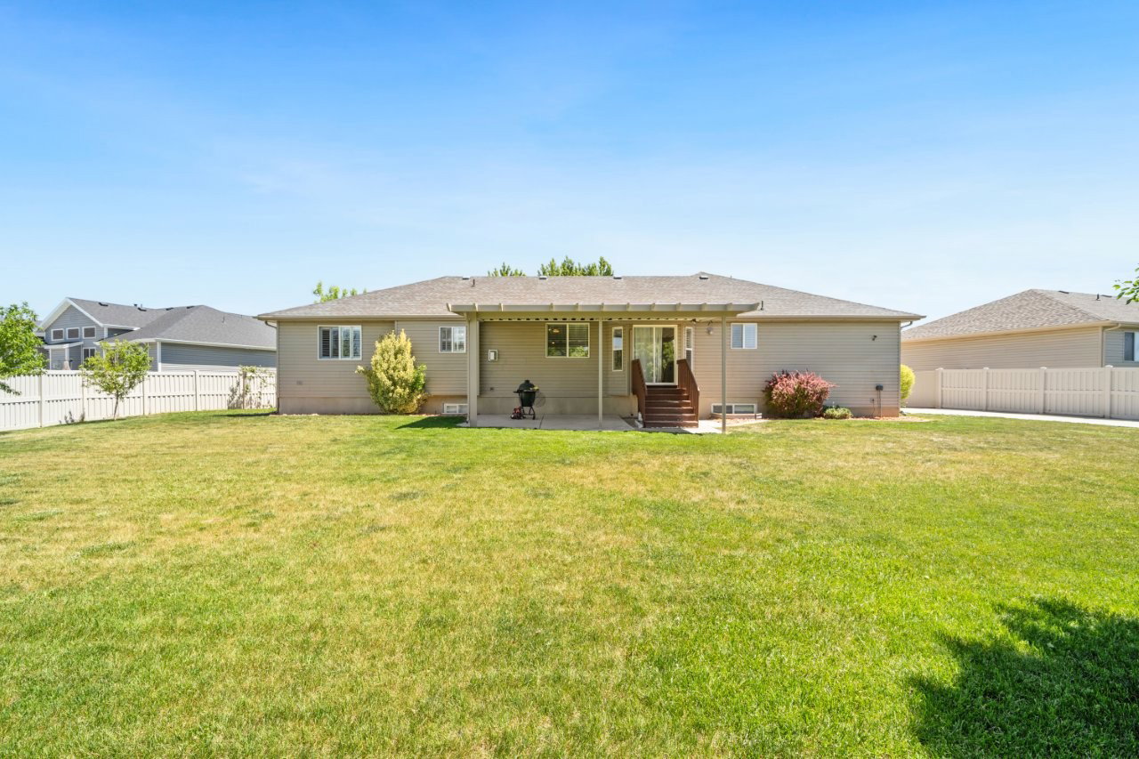 Expansive green lawn with a full vinyl privacy fence