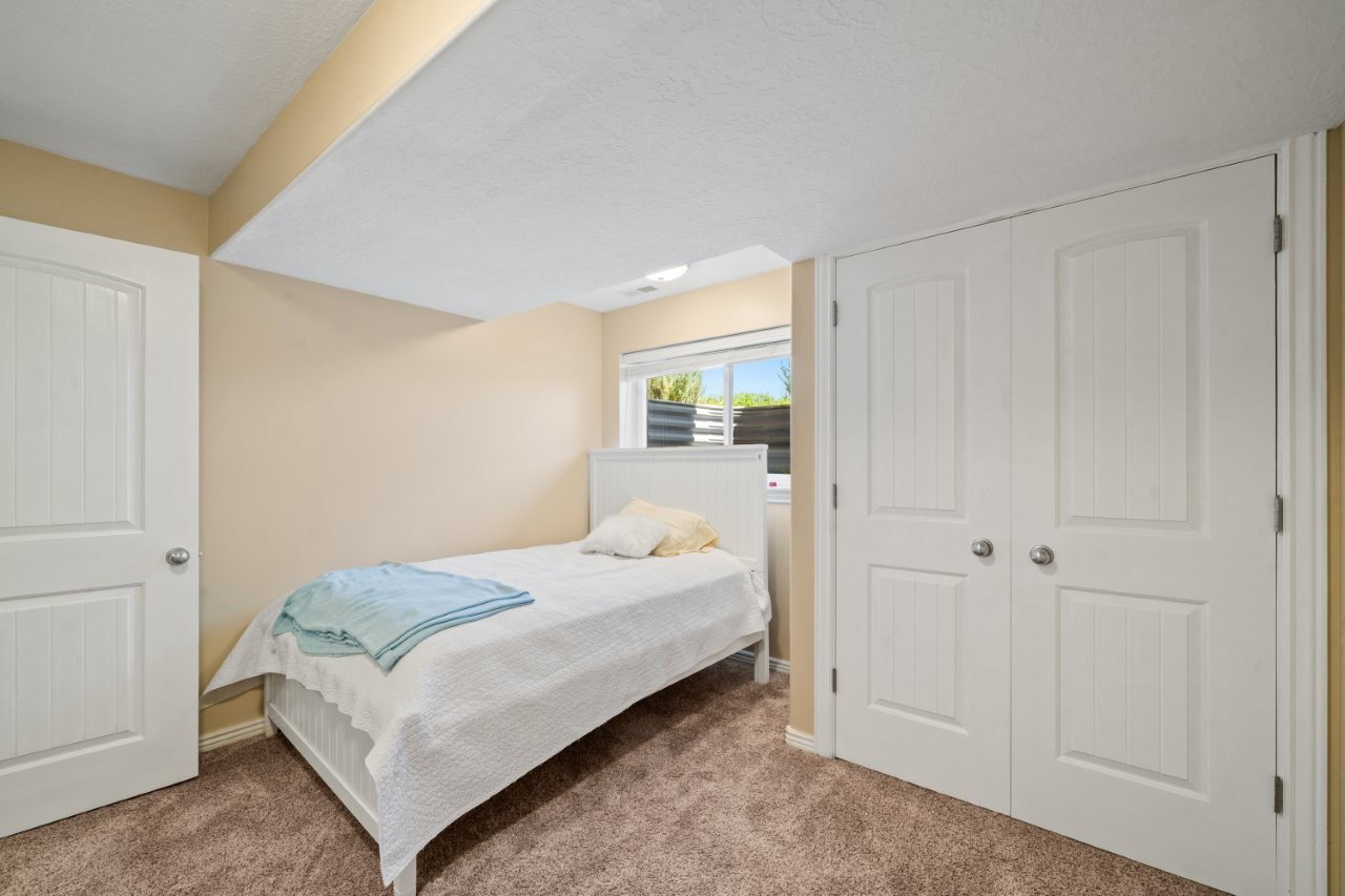 Neutral-toned room with plush carpet flooring, white trim, and a window providing natural light