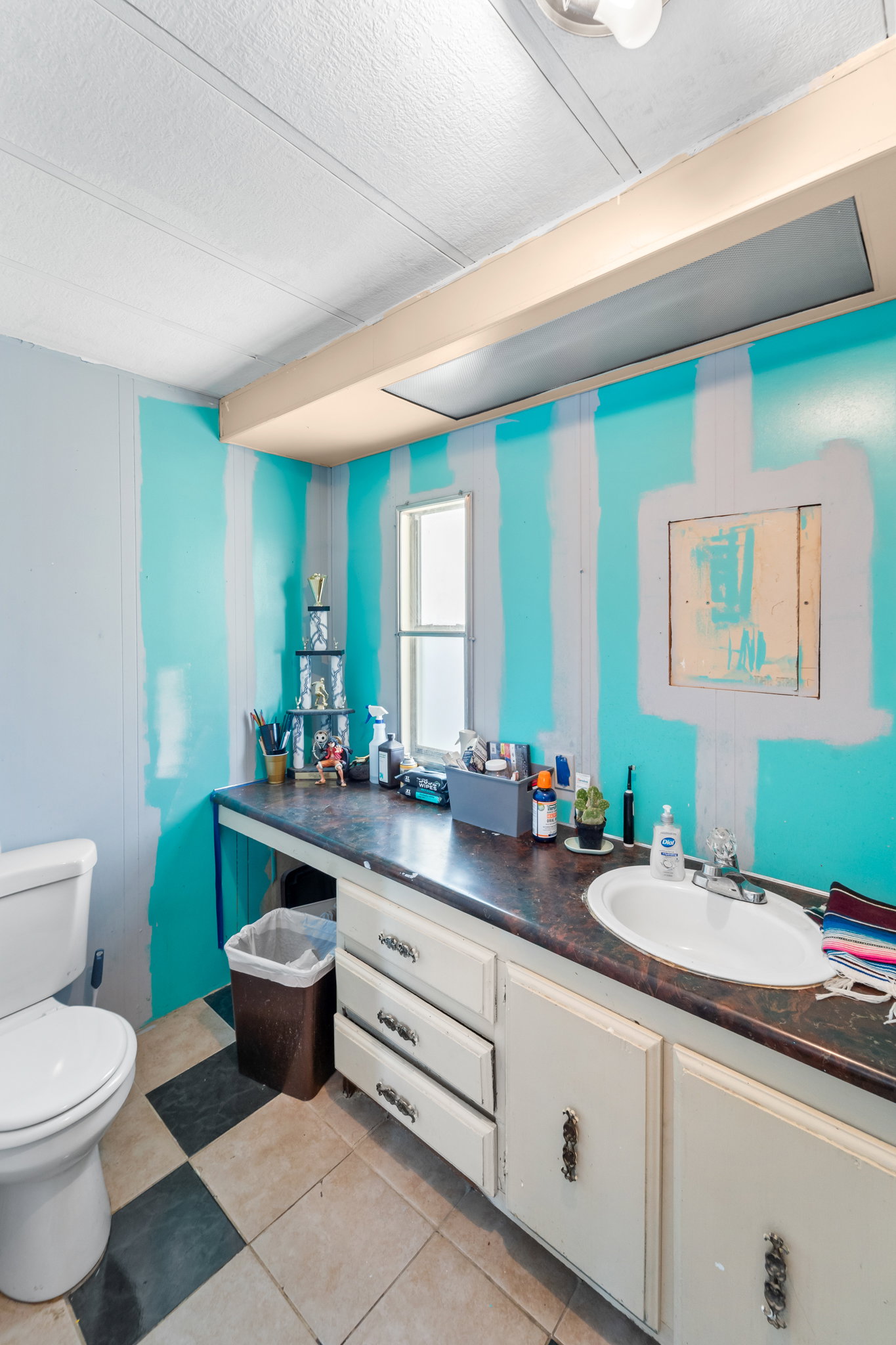 Bathroom featuring a built-in vanity with an integrated sink, checkerboard floor tiling, and a window