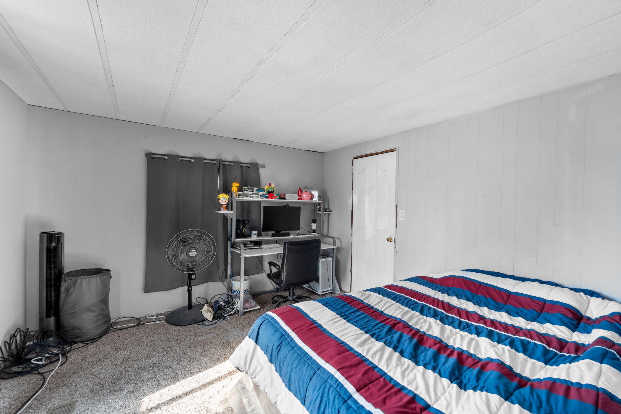 Room featuring gray wall paint, light-colored vertical paneling, and wall-to-wall carpeting