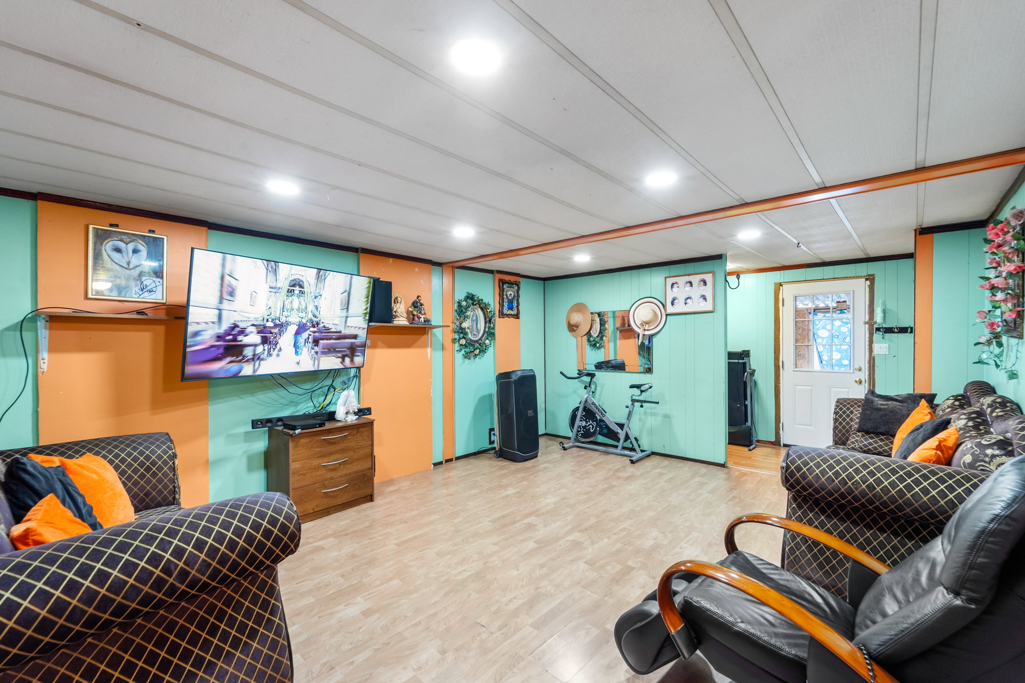 Spacious finished room featuring light wood-finish flooring, recessed lighting, and a white paneled ceiling