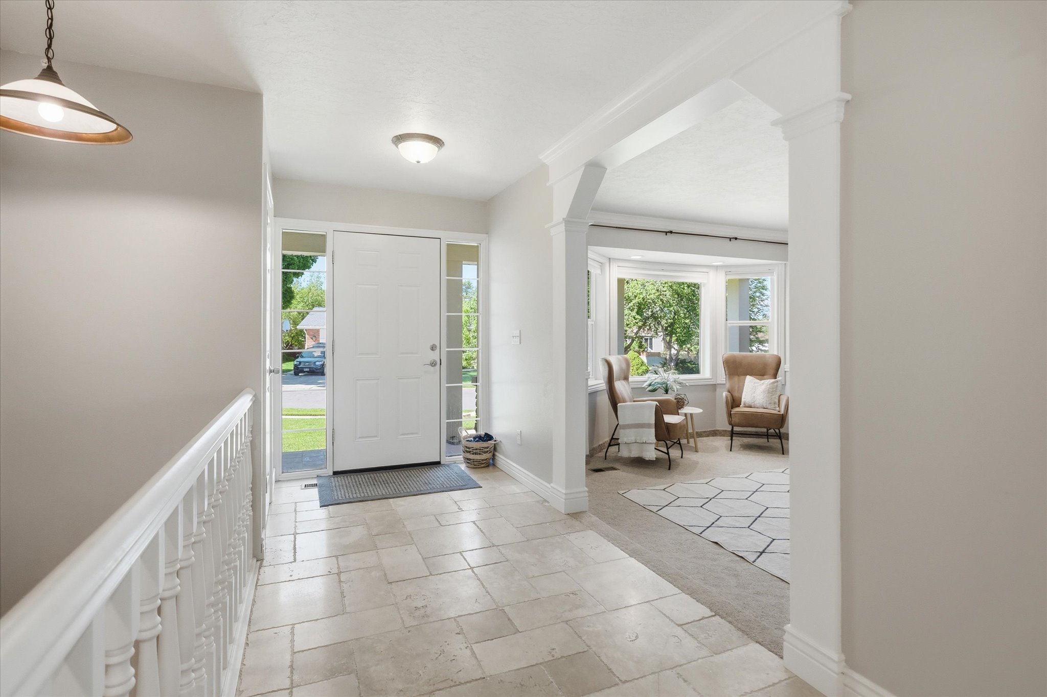 Entryway featuring large format rectangular tile flooring and a front door with sidelight windows