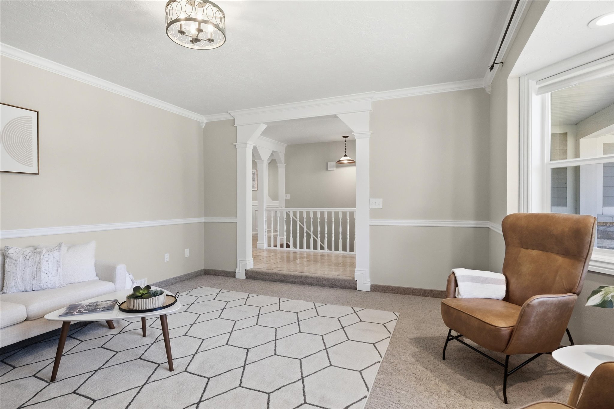Living space featuring crown molding, neutral wall tones, and a large window