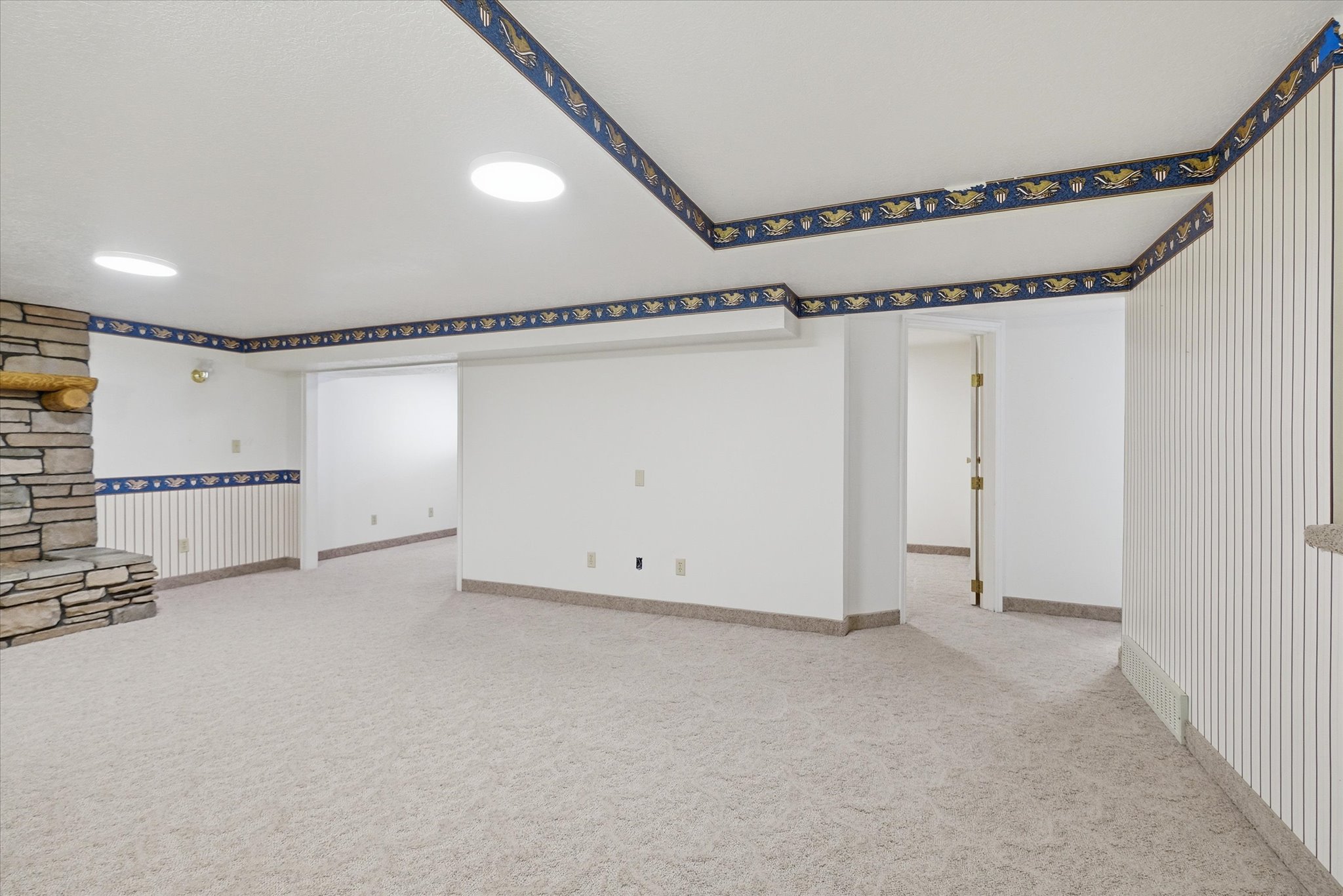 Spacious interior featuring a stone-clad fireplace and neutral carpeting