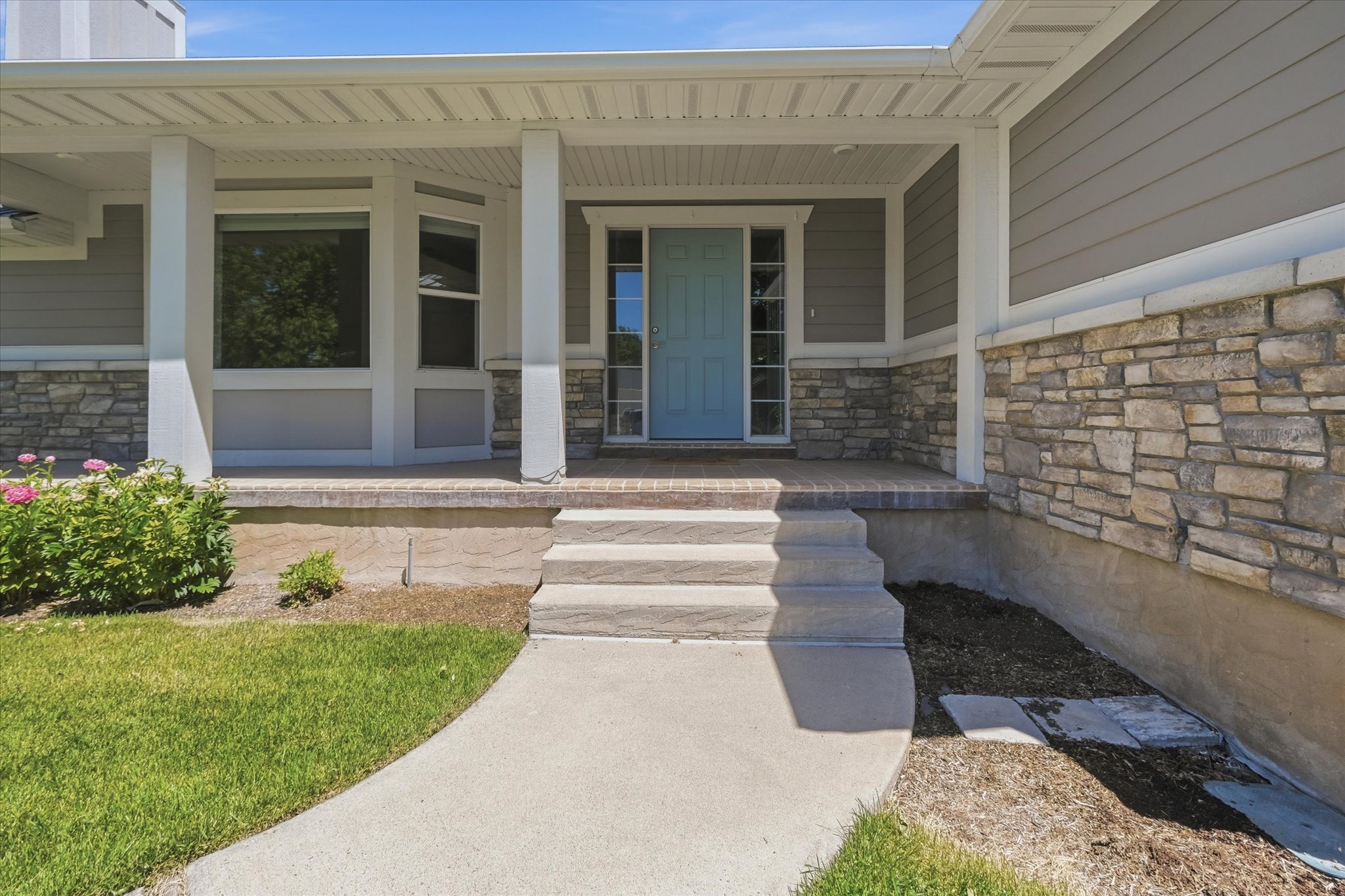 Inviting covered porch with a light blue entry door