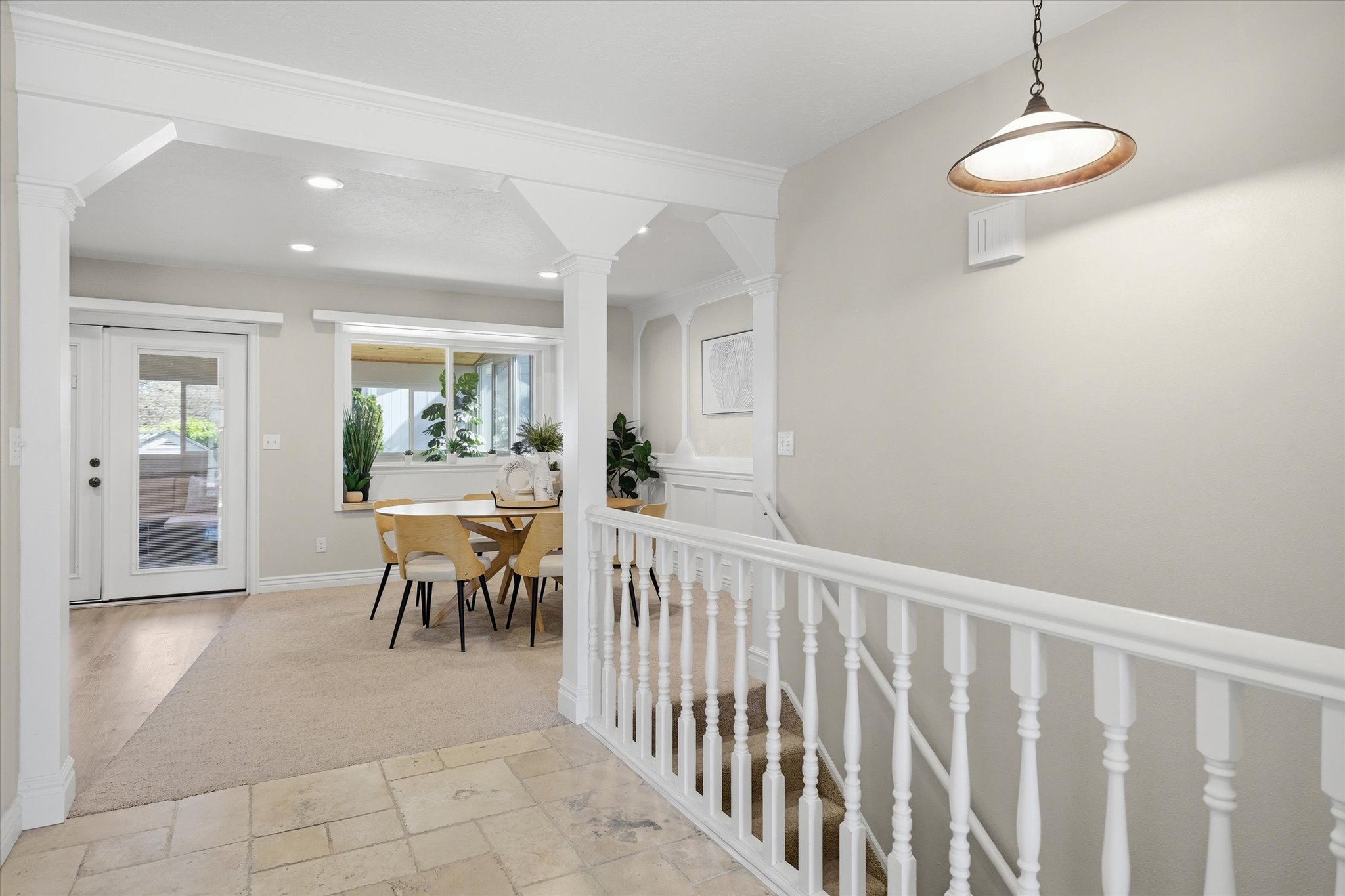 Light-toned tile flooring entryway featuring a classic white baluster staircase