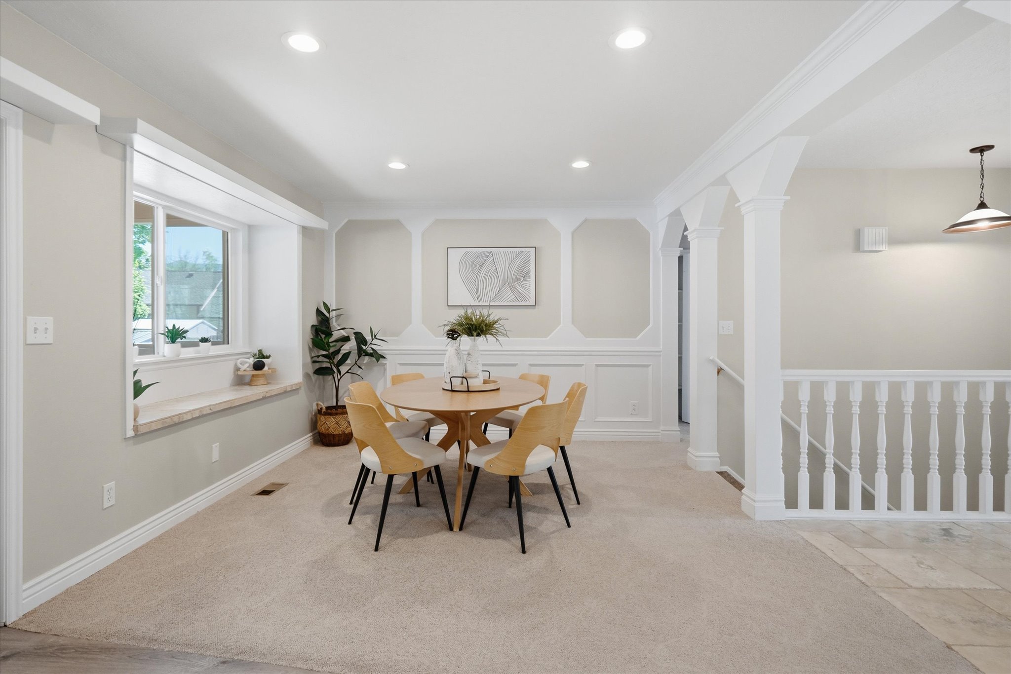 Dining area featuring recessed lighting, wainscoting, an integrated window seat, and broad archways