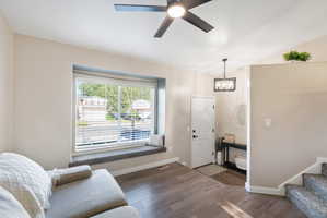 Living area featuring a window seat with carpet, wood-finish flooring, and a modern ceiling fan