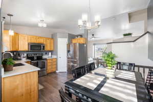 Kitchen and dining area featuring wood-finish cabinetry, stainless steel appliances,, and wood-finish flooring