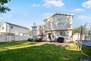 Spacious backyard featuring a large concrete patio, and a white vinyl privacy fence