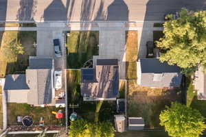 Aerial perspective showcasing the property with a dark shingle roof and a concrete driveway