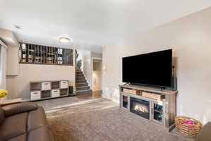 Open living area featuring textured carpeting, neutral wall tones