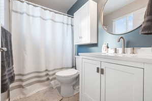 Bathroom featuring a white vanity with panel-front cabinetry, a white countertop, and a contemporary brushed nickel faucet