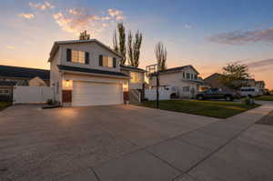 Two-story residence featuring siding and brick accents, an integrated garage, and a concrete driveway