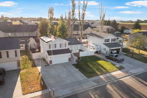 Two-story residence with an attached garage, white vinyl siding, and dark shutters