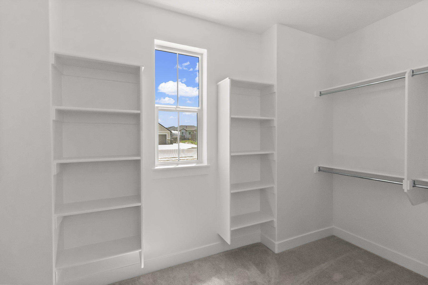 Primary Suite walk in Closet w/ lots of shelving, hanging space & natural light.