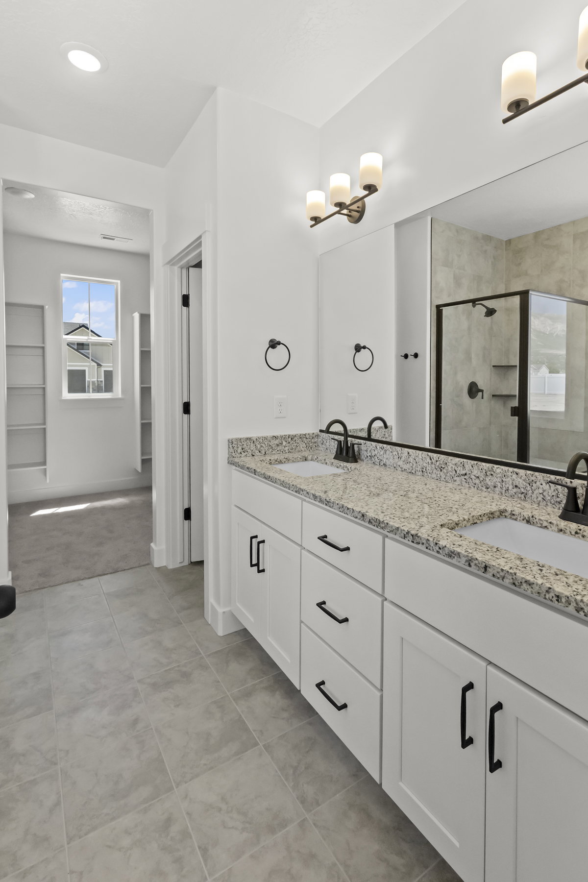 Dual vanity white shaker cabinetry, and matte black hardware