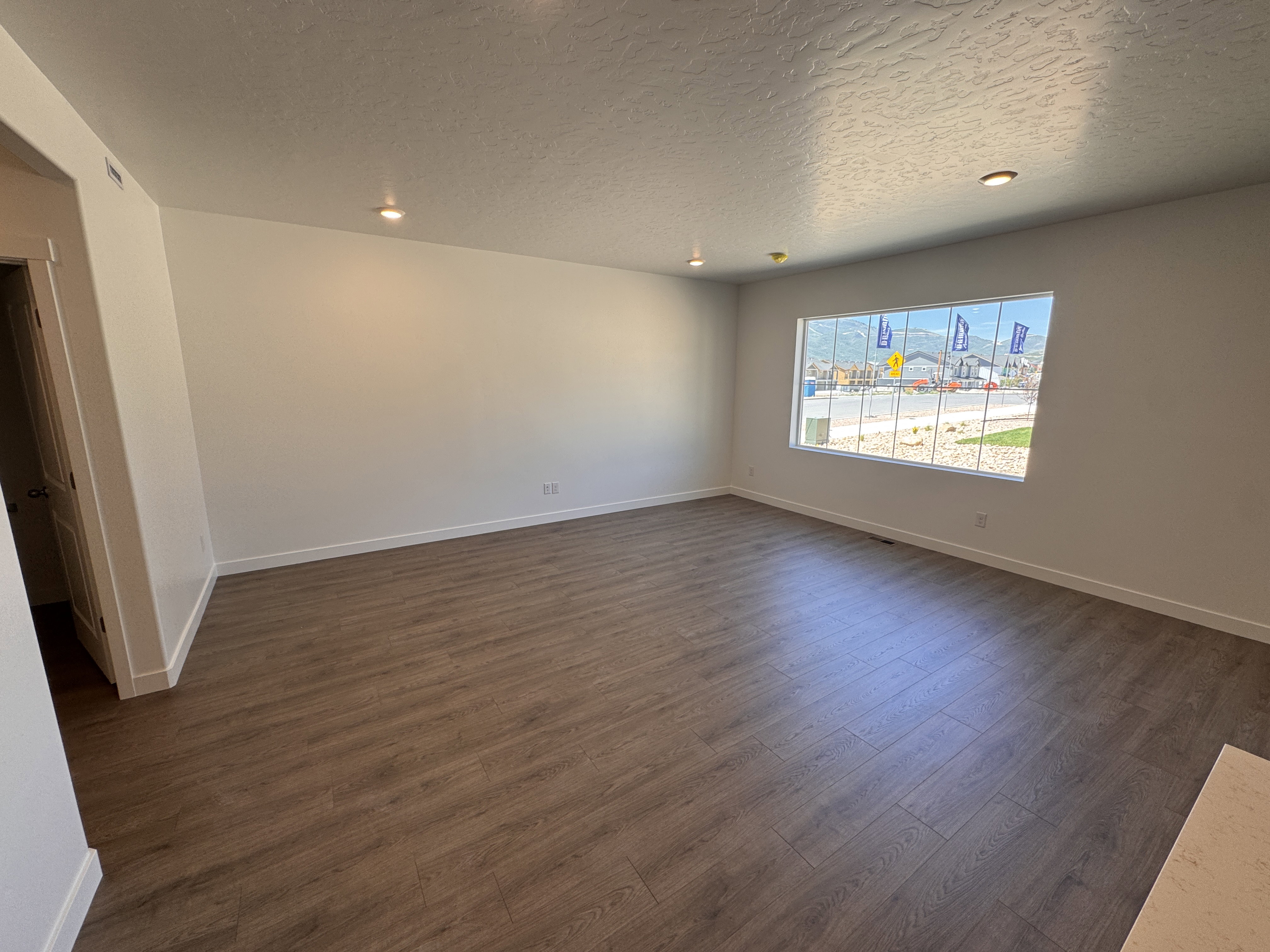 Spacious room featuring wood-finish flooring, recessed lighting, and a large window with mountain scenery