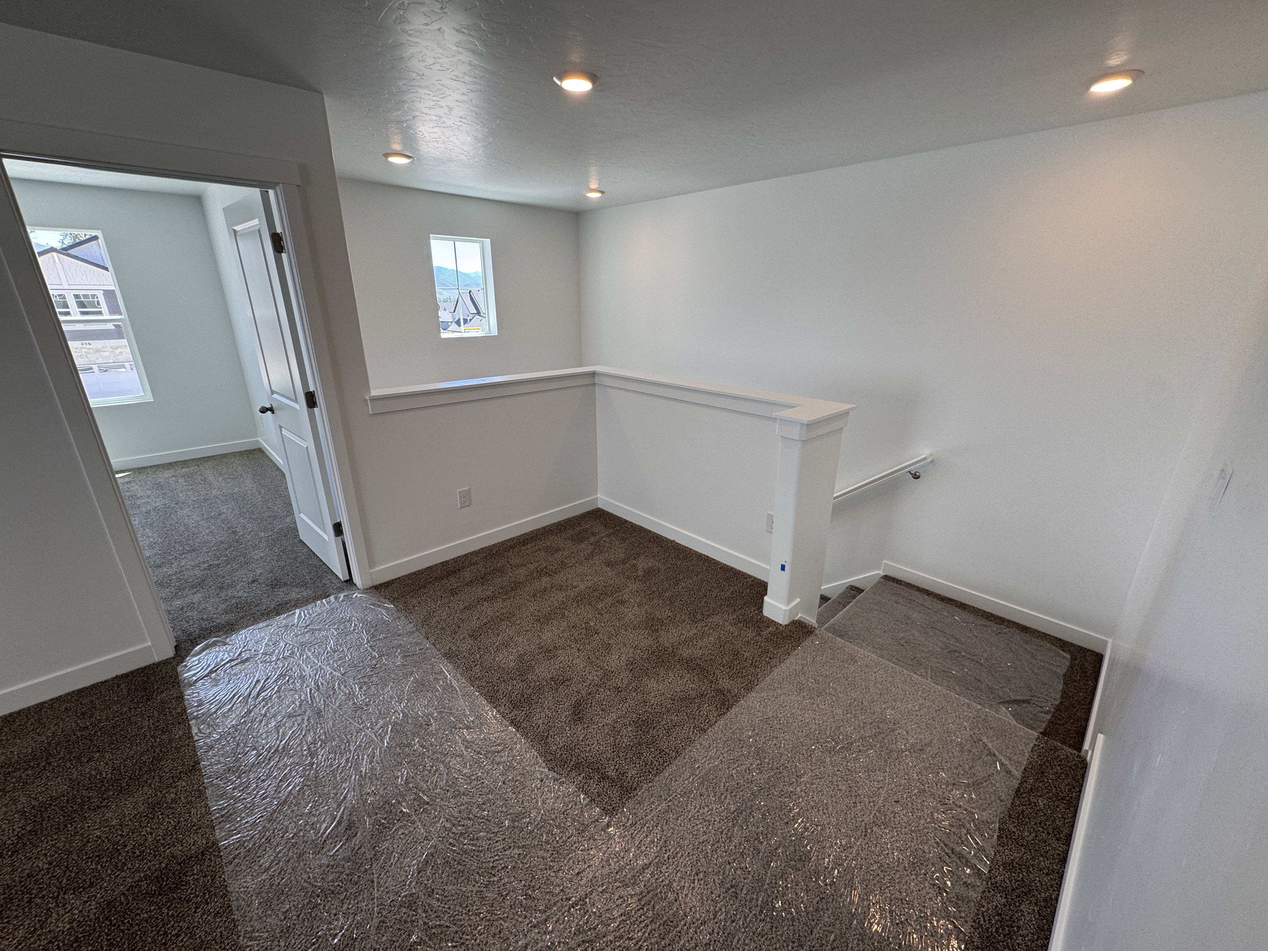 Upper-level landing area featuring neutral-toned carpeting and recessed lighting