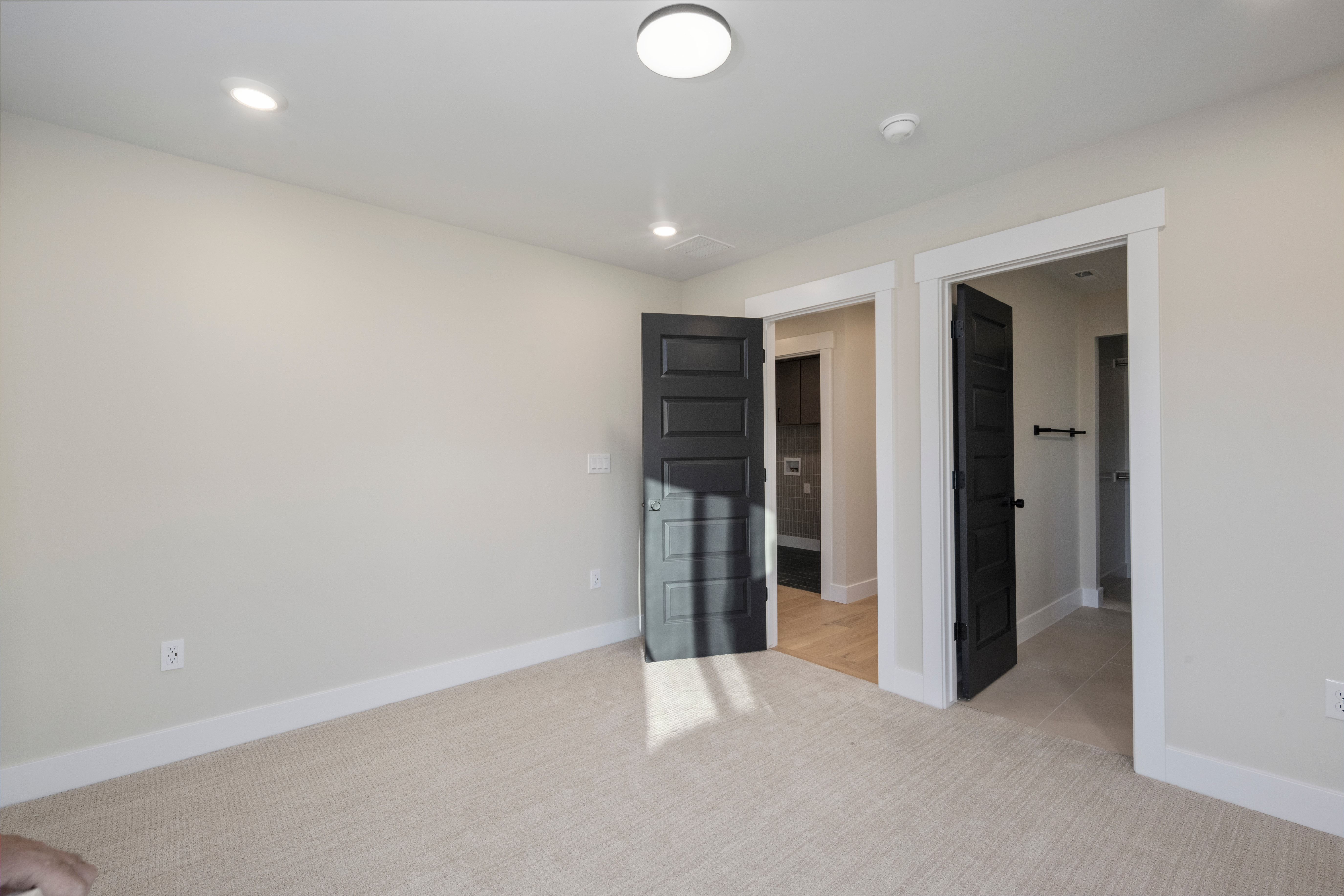 Spacious room featuring neutral carpeting, light-toned walls, and recessed lighting