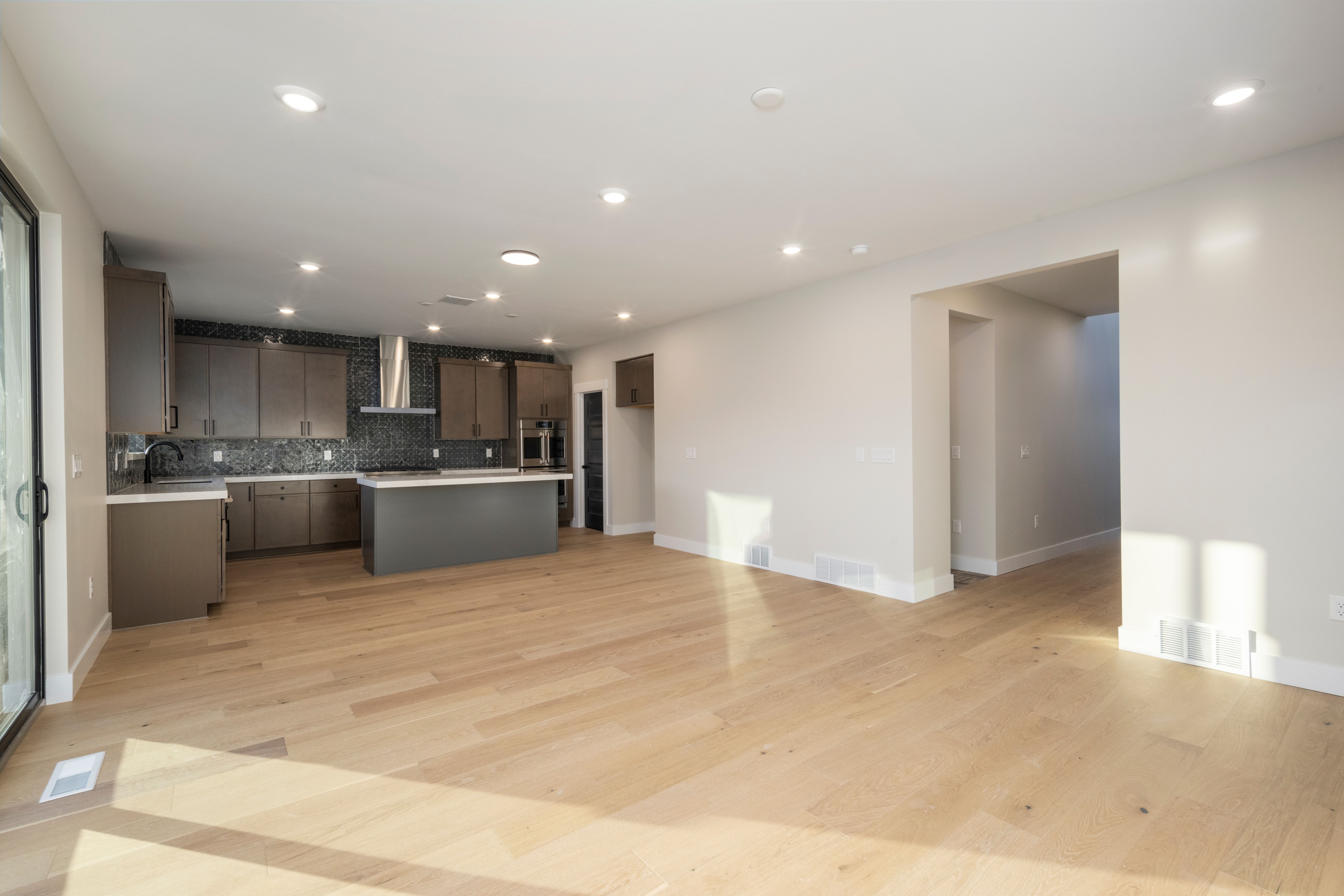 Spacious open concept living area featuring light wood-finish flooring and recessed lighting