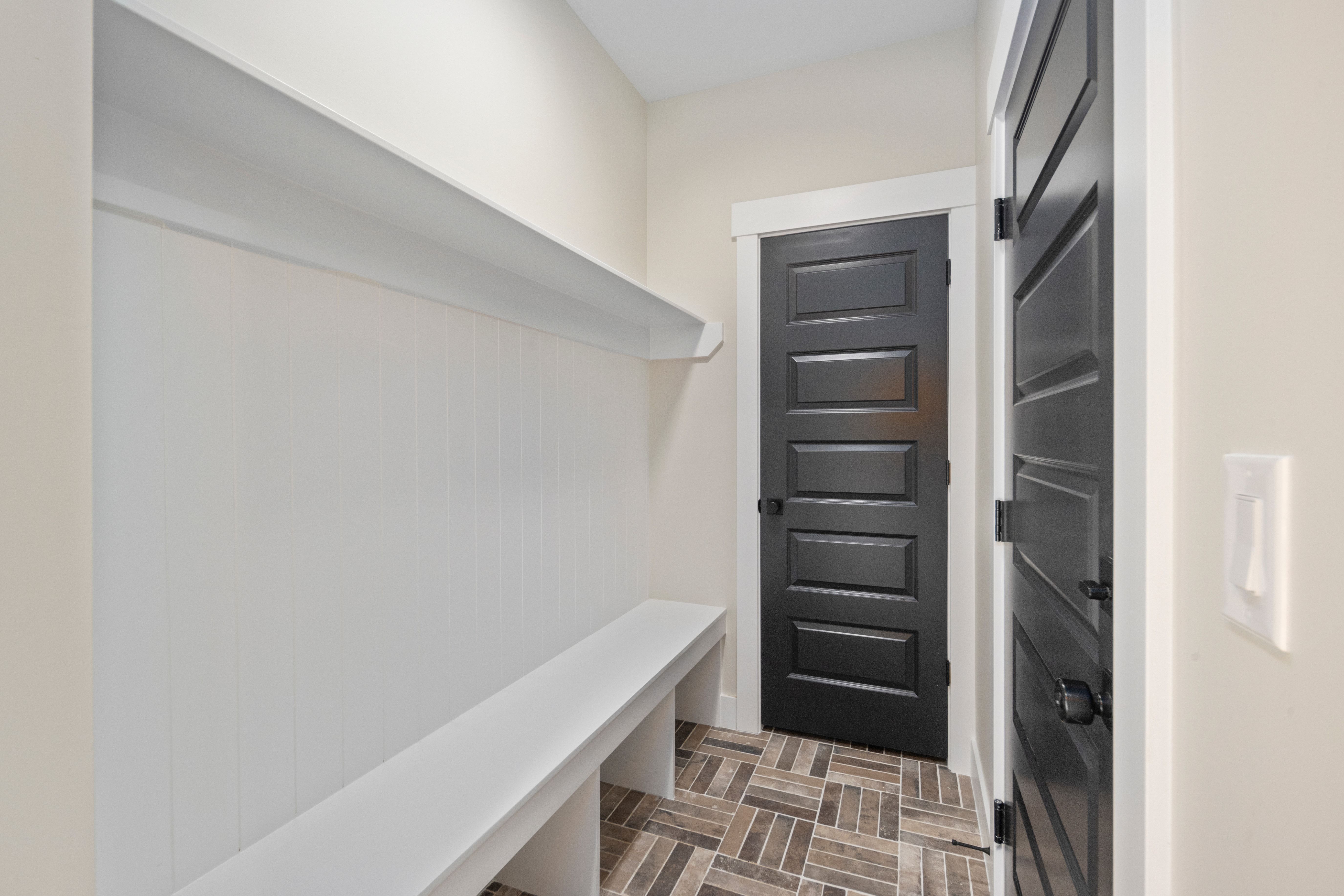 Built-in white bench and shelving with beadboard backing