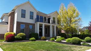 Stucco and brick exterior with a columned portico