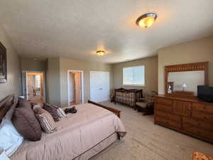 Spacious carpeted room featuring a window with blinds, dual bi-fold closet doors, and two interior doorways