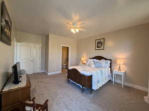 Carpeted bedroom featuring neutral wall tones and a ceiling fan with integrated lighting