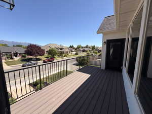 Outdoor balcony featuring wood-finish decking and black iron railings