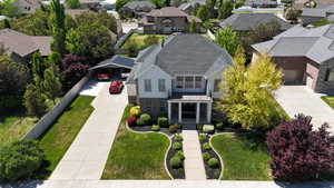 Traditional-style residence featuring a two-story design, a covered front porch, and a dark shingle roof