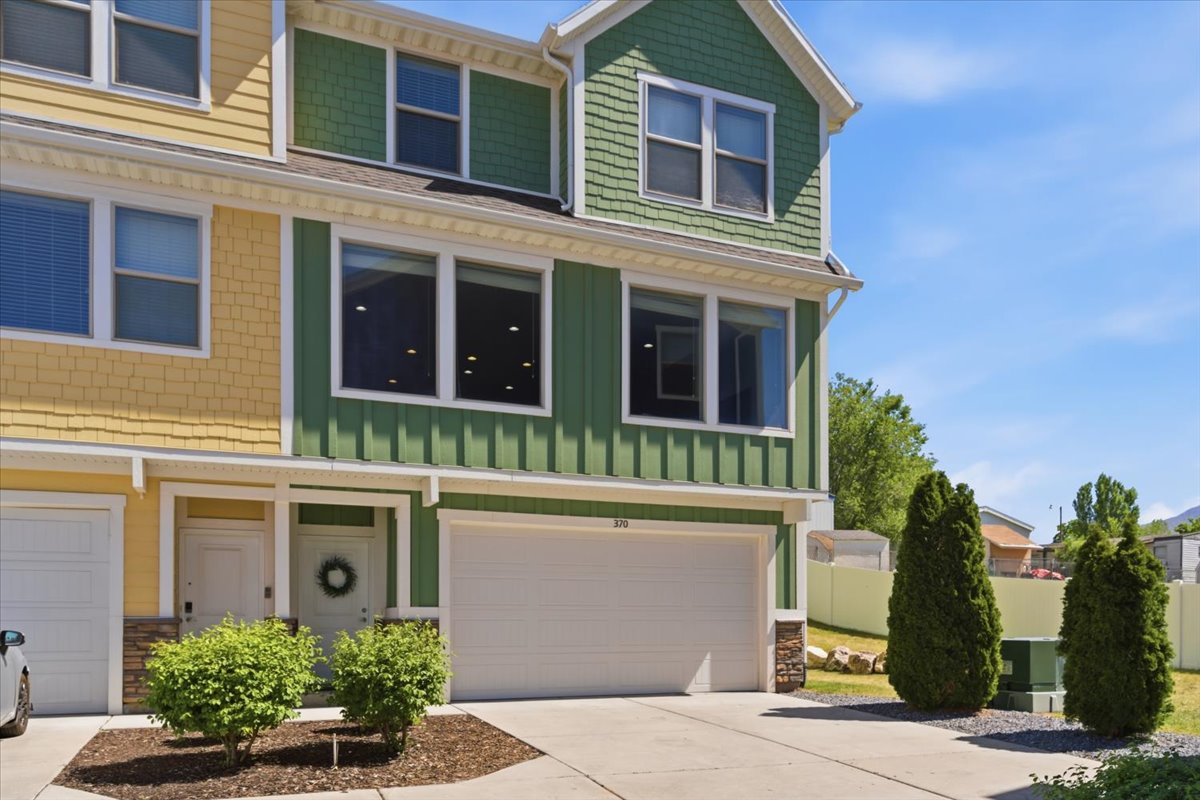 Three-story townhouse exterior with a two-car garage and a paved driveway